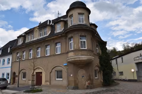 Zwangsversteigerung Mehrfamilienhaus in Glauchau – Vorderansicht des dreigeschossigen Eck-Wohn- und Geschäftshauses Breite Straße 1 und 2.