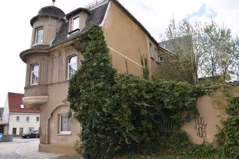 Zwangsversteigerung Mehrfamilienhaus in Glauchau – Südostansicht mit Erdgeschossanbau als Überbau auf Flurstück 1750.