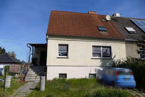 Zwangsversteigerung Doppelhaushälfte in Burgstall, Dolle – Ansicht des Gebäudes von links mit Grundstückszufahrt.