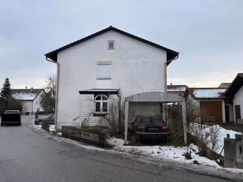 Zwangsversteigerung Zweifamilienhaus in Oberpöring – Nordwestansicht des Zweifamilienhauses mit Carport und Zufahrt.