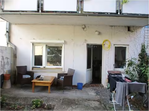 Zwangsversteigerung Mehrfamilienhaus in Bremen, Neustadt – Rückansicht des Objekts mit Hof- und Terrassenbereich.