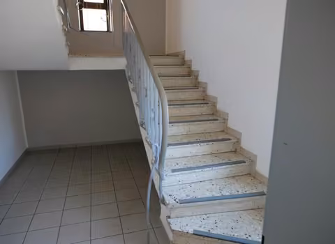 Zwangsversteigerung Mehrfamilienhaus in Fulda – Innenansicht der zentralen Treppenanlage des Gebäudes.