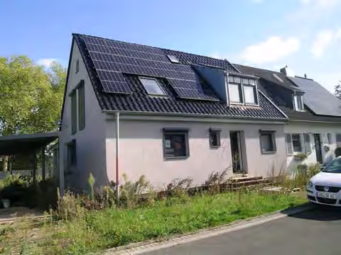 Zwangsversteigerung Doppelhaushälfte in Düsseldorf, Urdenbach – Straßenansicht der Doppelhaushälfte mit Solardach und Vorgartenbereich.