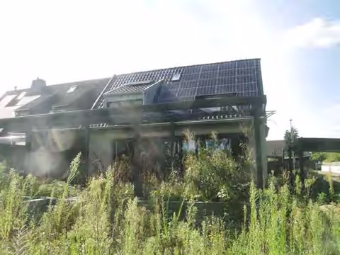 Zwangsversteigerung Doppelhaushälfte in Düsseldorf, Urdenbach – Rückwärtige Gartenansicht mit Anbau und Terrasse.