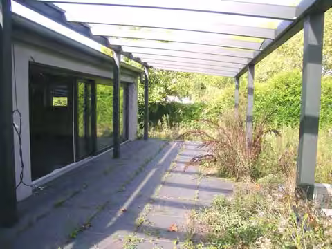 Zwangsversteigerung Doppelhaushälfte in Düsseldorf, Urdenbach – Terrasse mit moderner Schiebetüranlage und Stahlpergola.