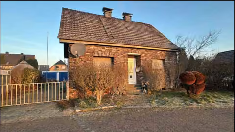 Zwangsversteigerung Einfamilienhaus in Alpen, Menzelen – Straßenseitige Süd-Ost-Ansicht des freistehenden Einfamilienhauses mit Vorgarten.