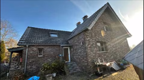 Zwangsversteigerung Einfamilienhaus in Alpen, Menzelen – West-Ansicht des Wohnhauses mit Haupt- und Anbau.