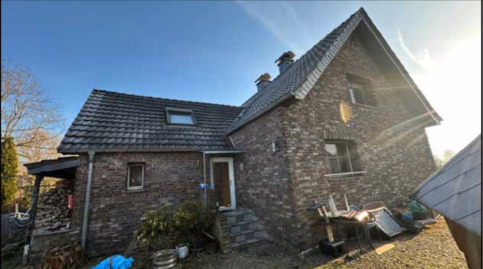 Zwangsversteigerung Einfamilienhaus in Alpen, Menzelen – West-Ansicht des Wohnhauses mit Haupt- und Anbau.