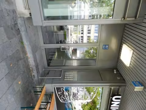 Zwangsversteigerung Eigentumswohnung in München, Laim – Treppenhaus mit massiven Treppenläufen und Kunststeinbelag.