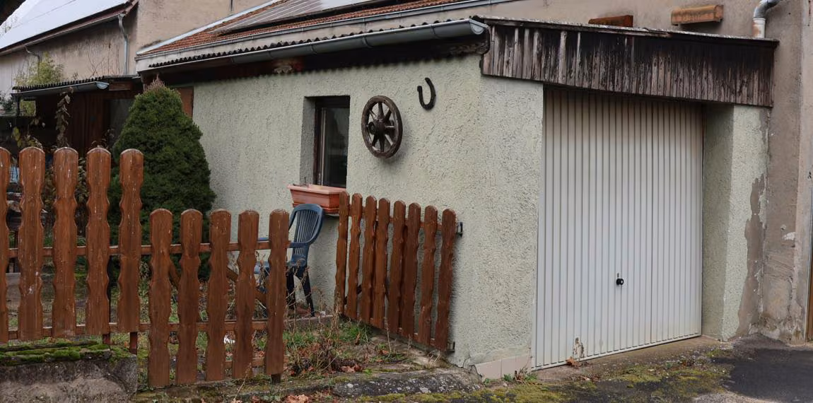 Zwangsversteigerung Einfamilienhaus in Wiesentheid, Geesdorf – Ansicht der massiven Einzelgarage mit Holzverkleidung und Garagentor.