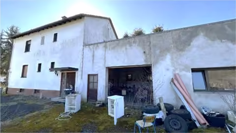 Zwangsversteigerung Zweifamilienhaus in Waldsolms, Hasselborn – Ansicht der Gebäuderückseite mit angebautem Garagengebäude.