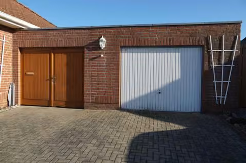 Zwangsversteigerung Einfamilienhaus in Klötze – Straßenansicht der massiven Garage mit Zufahrt.
