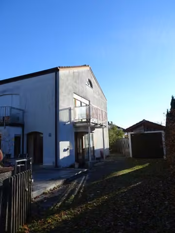 Zwangsversteigerung Doppelhaushälfte in Gauting – Ansicht von der Frühlingstraße mit Garagenzufahrt.