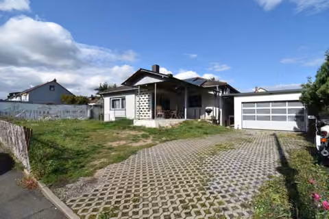 Zwangsversteigerung Einfamilienhaus in Wendelstein, Kleinschwarzenlohe – Vorderansicht des Bungalows mit Zufahrt und Garage.
