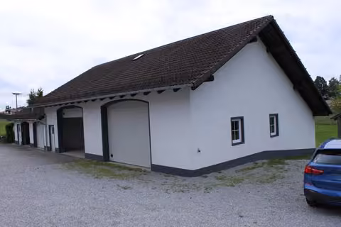 Zwangsversteigerung Einfamilienhaus in Hofkirchen, Solla – Lagerhalle und angebaute Garagen von Nordwesten mit Vorplatz.