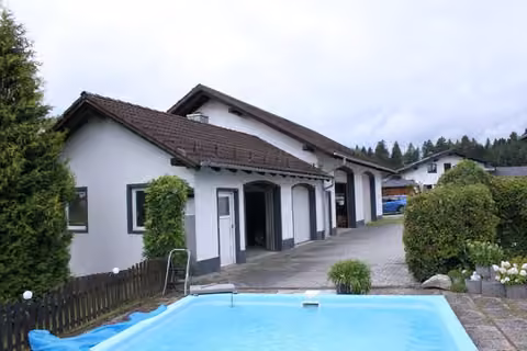 Zwangsversteigerung Einfamilienhaus in Hofkirchen, Solla – Außenanlagen mit GfK-Poolbecken, Garagentrakt und Umgebungsbegrünung.