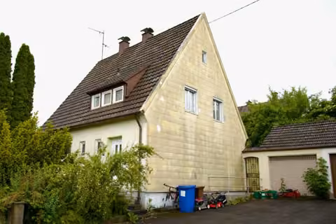 Zwangsversteigerung Einfamilienhaus in Wertingen – Westfassade und Giebelseite des Wohnhauses mit Blick auf die Garage.