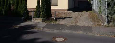 Zwangsversteigerung Einfamilienhaus in Hammelburg – Vorderansicht des Wohnhauses von Süd-Osten mit Zufahrt zur Garage.