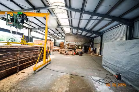 Zwangsversteigerung Grundstück in Lychen, Retzow – Außenbereich mit Holzlagerung und Gerätschaften.