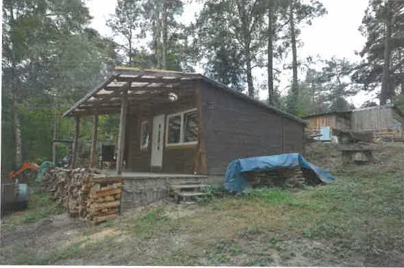 Zwangsversteigerung Grundstück in Rheinsberg, Kagar – Einfaches Ferienhaus aus Holz mit Nebengebäude im Wald.