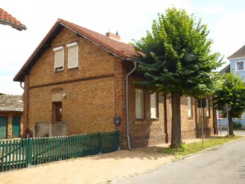 Zwangsversteigerung Zweifamilienhaus in Schipkau, Annahütte – Straßenansicht der Doppelhaushälfte mit Eingang Nummer 62