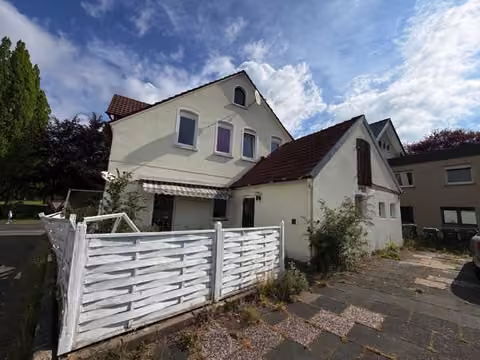 Zwangsversteigerung Einfamilienhaus in Hiddenhausen, Eilshausen – Südansicht des Hauses mit Terrasse und ehemaligem Stallanbau.