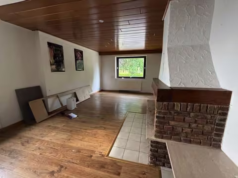 Zwangsversteigerung Einfamilienhaus in Hiddenhausen, Eilshausen – Wohnzimmer im Erdgeschoss mit gemauertem Kamin.