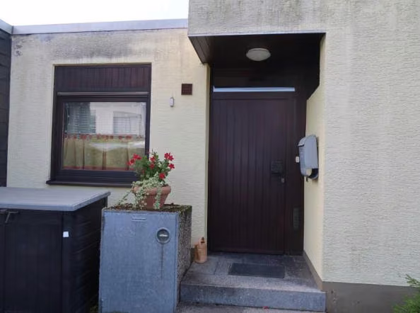 Zwangsversteigerung Einfamilienhaus in Meckenheim – Detailansicht der Hauseingangstür mit Überdachung und Eingangsstufen.