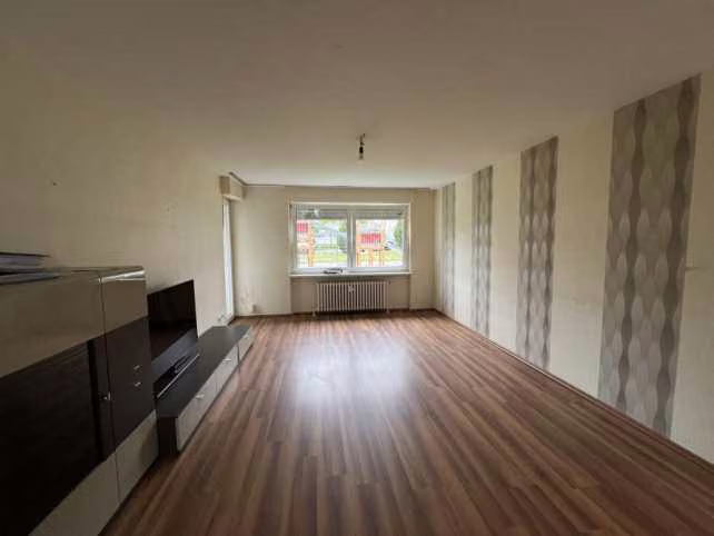 Zwangsversteigerung Eigentumswohnung in Bielefeld, Brake – Helles Wohnzimmer mit Laminatboden und Fensterfront
