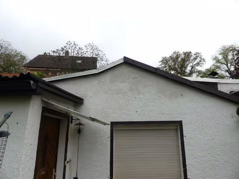 Zwangsversteigerung Einfamilienhaus in Dresden, Cossebaude – Vorderansicht des eingeschossigen Wohnhauses mit Doppelgarage und Zufahrtsbereich.