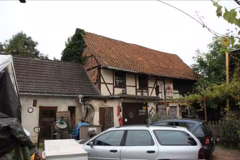 Zwangsversteigerung Wohn-/Geschäftshaus in Quedlinburg, Gernrode – Hofansicht des Nebengelasses mit Toreinfahrt und Fachwerkstruktur.