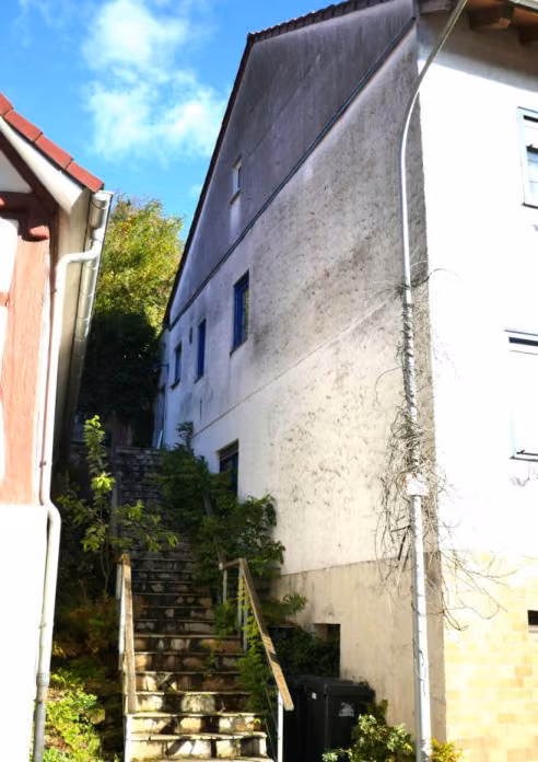 Zwangsversteigerung Einfamilienhaus in Breuberg, Neustadt – Ansicht Südwest mit der massiven Außentreppe zum Hang-Garten.