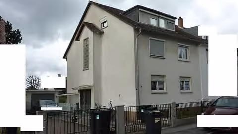 Zwangsversteigerung Mehrfamilienhaus in Darmstadt, Arheilgen – Straßen- und Seitenansicht des Dreiparteienwohnhauses mit Vorgarten.