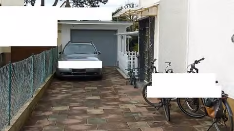Zwangsversteigerung Mehrfamilienhaus in Darmstadt, Arheilgen – Hofzufahrt, Hauseingang und massive Garage mit Garagentor.