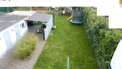 Zwangsversteigerung Mehrfamilienhaus in Darmstadt, Arheilgen – Rückwärtiger Gartenbereich mit Rasenfläche und Blick zur Garage.