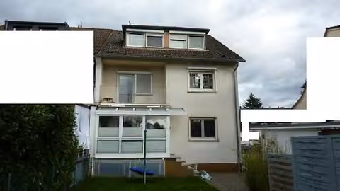 Zwangsversteigerung Mehrfamilienhaus in Darmstadt, Arheilgen – Rückansicht des Wohngebäudes mit Wintergarten und Dachgaube.