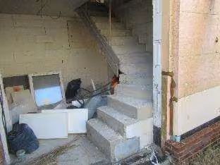 Zwangsversteigerung Einfamilienhaus in Moorweg – Innenaufnahme mit Rohbau-Betontreppe ins Obergeschoss.