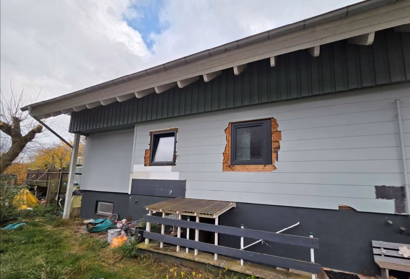 Zwangsversteigerung Einfamilienhaus in Salzhemmendorf, Ockensen – Seitenansicht des Wohnhauses mit Außenzugang zum Kellergeschoss.