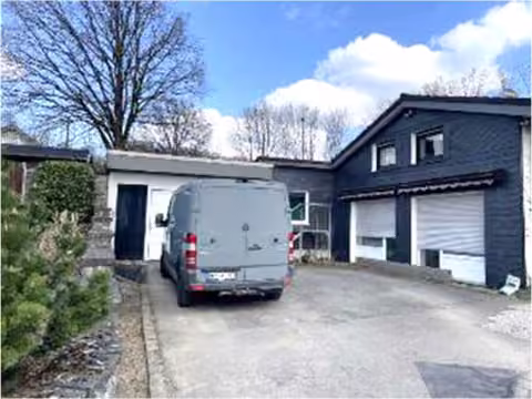 Zwangsversteigerung Einfamilienhaus in Meinerzhagen – Vorderansicht des Einfamilienhauses mit Hauseingangsbereich und Vorplatz.