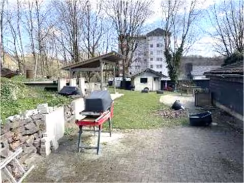 Zwangsversteigerung Einfamilienhaus in Meinerzhagen – Gartenbereich mit überdachter Sitzecke und Gartenhütte.