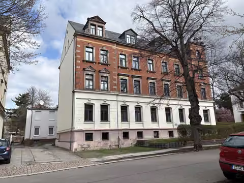 Zwangsversteigerung Eigentumswohnung in Chemnitz, Hilbersdorf – Straßenansicht mit Grundstückszufahrt, Stellplatzbereich und Teilansicht des Hintergebäudes.