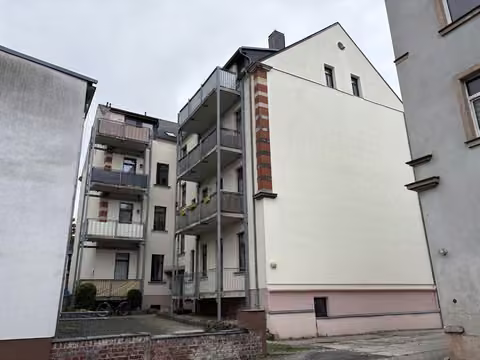 Zwangsversteigerung Eigentumswohnung in Chemnitz, Hilbersdorf – Hof- und Rückansicht des Gebäudes mit Balkonanbauten.