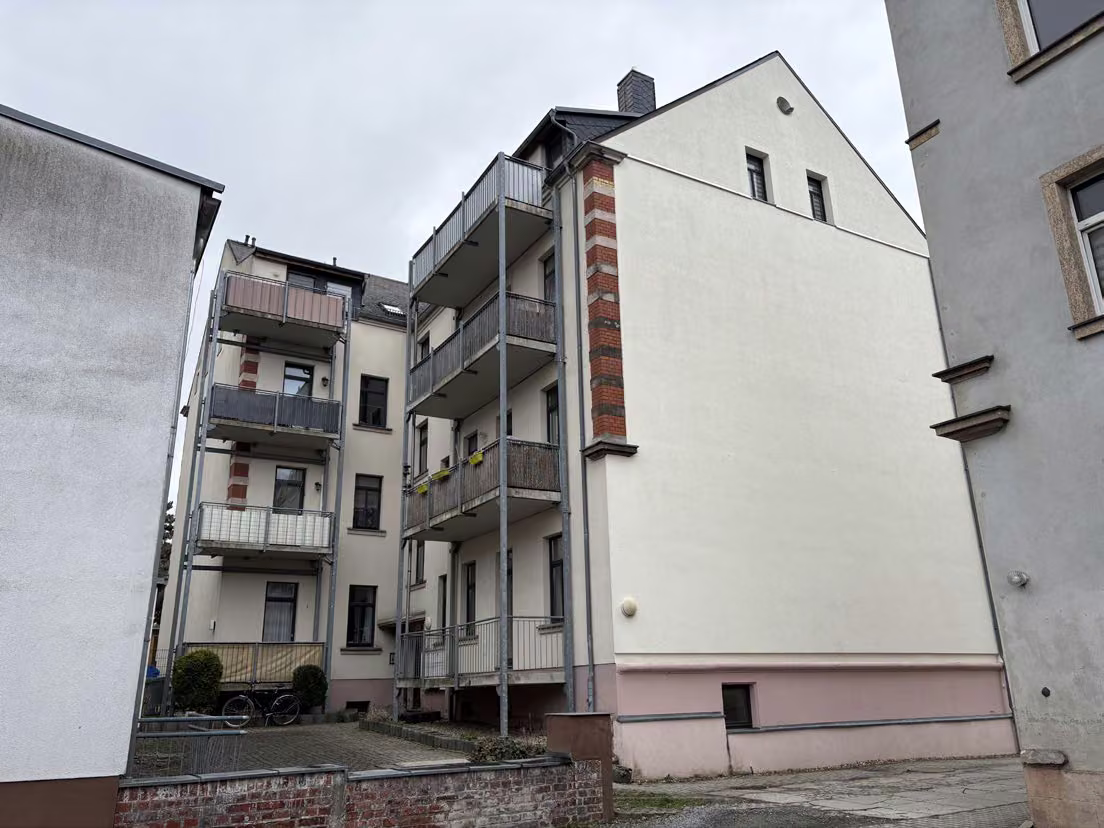 Zwangsversteigerung Eigentumswohnung in Chemnitz, Hilbersdorf – Hof- und Rückansicht des Gebäudes mit Balkonanbauten.