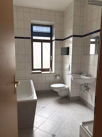 Zwangsversteigerung Eigentumswohnung in Chemnitz, Hilbersdorf – Tageslichtbadezimmer mit Fenster, Badewanne, Dusche und Sanitärausstattung.