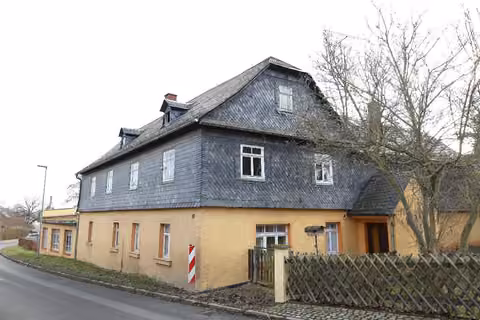 Zwangsversteigerung Einfamilienhaus in Zeulenroda-Triebes, Mehla – Nordwestansicht des ländlichen Wohnhauses mit Straßenverlauf.
