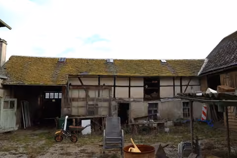 Zwangsversteigerung Einfamilienhaus in Zeulenroda-Triebes, Mehla – Westansicht der Scheune und Hofbereich mit erkennbaren Ablagerungen.