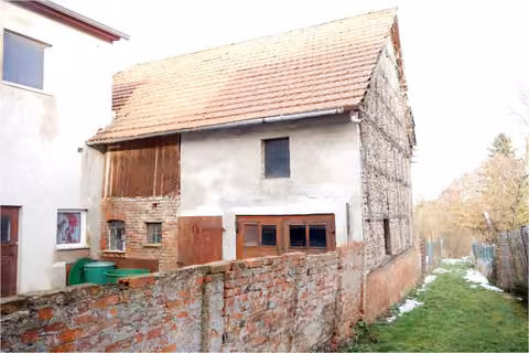 Zwangsversteigerung Einfamilienhaus in Freienbessingen – Nebengebäude Südansicht (ehemalige Scheune/Stallung mit Hoftor und Ziegelmauer).
