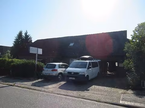 Zwangsversteigerung Doppelhaushälfte in Schortens – Straßenansicht der Doppelhaushälfte mit Einfahrt und Stellplätzen