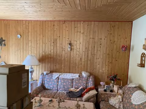 Zwangsversteigerung Einfamilienhaus in Wittmund – Wohnzimmer im Erdgeschoss mit Holzdeckenverkleidung.