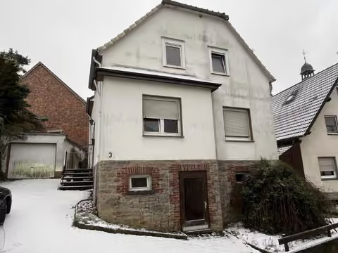 Zwangsversteigerung Einfamilienhaus in Marsberg, Padberg – Straßenansicht des freistehenden Einfamilienhauses mit Hauseingang und Giebel.